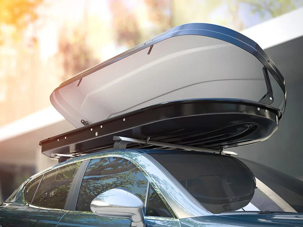 Acrylic roof box mounted on car roof rack, outdoor setting, glossy finish