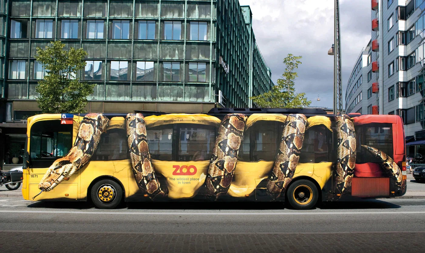 Bus with large snake print advertising wrap, city street background, outdoor advertising
