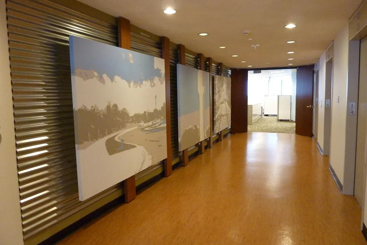Modern office hallway with large canvas wall art and bright overhead lighting