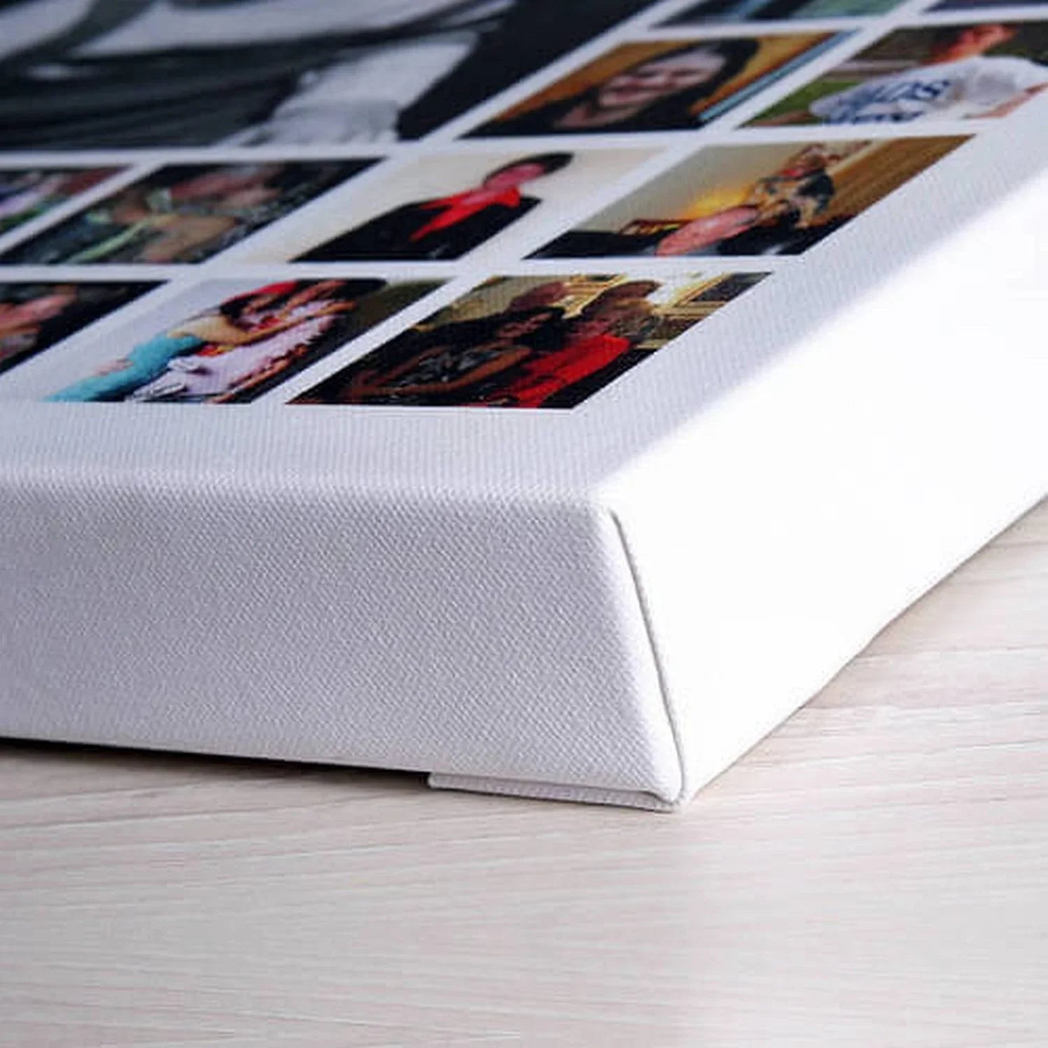Canvas photo collage on wood surface, stretched on a thick white frame, close-up corner view