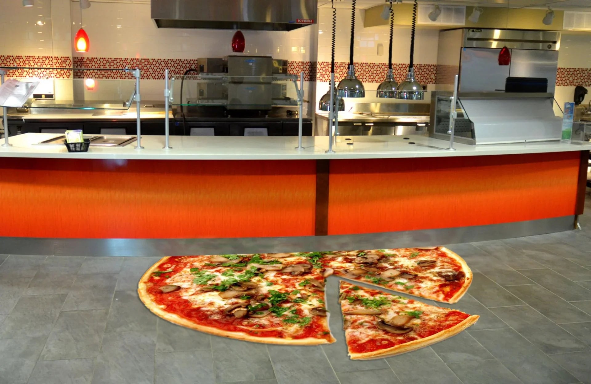 Restaurant counter with large pizza floor graphic, advertising materials, tiled floor